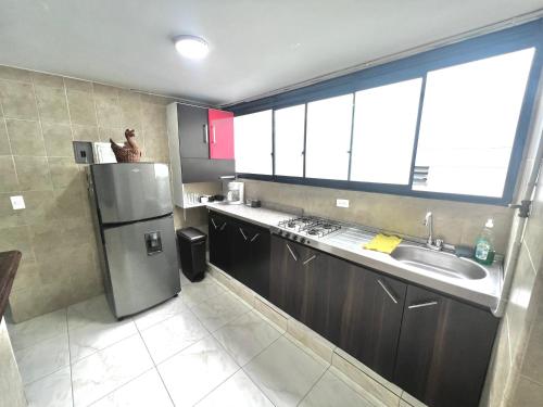 a kitchen with a stainless steel refrigerator and a sink at APARTAMENTO 401 MEDELLIN in Medellín