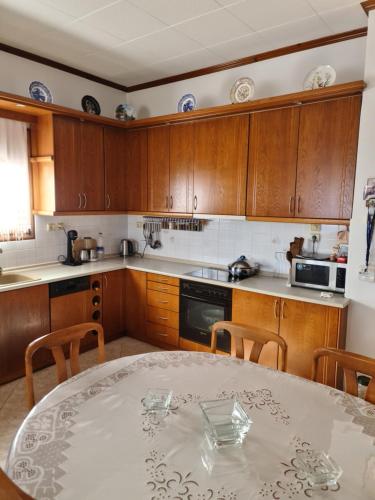 eine Küche mit einem Tisch und einigen Holzschränken in der Unterkunft Votsi Seaview in Alonnisos Altstadt