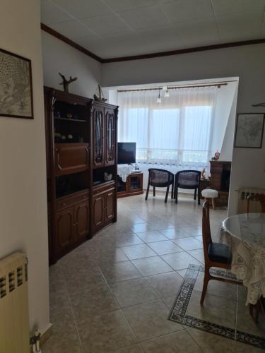 a living room with a table and chairs and a large window at Votsi Seaview in Alonnisos