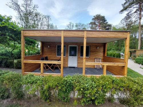 a small wooden cabin with a large deck at Ferienbungalows am Wolziger See in Heidesee