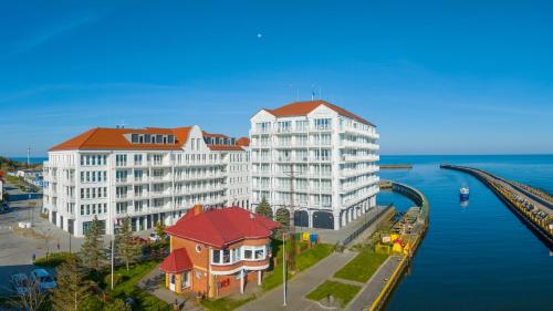 a rendering of a large building next to the water at Marina Royale Darłowo - Apartamenty Ultra Mar nad morzem in Darlowko