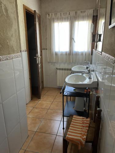 a bathroom with two sinks and a window at Las Tejeruelas Casa Rural in Navacepedilla de Corneja