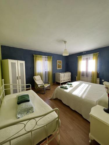 a bedroom with two beds and a blue wall at Las Tejeruelas Casa Rural in Navacepedilla de Corneja