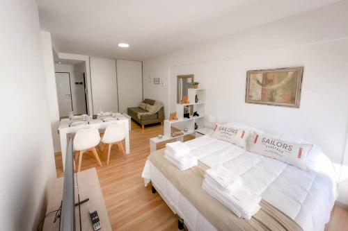 Dormitorio blanco con cama y mesa con sillas en Jufre I - Amazing Studio in Palermo Soho en Buenos Aires