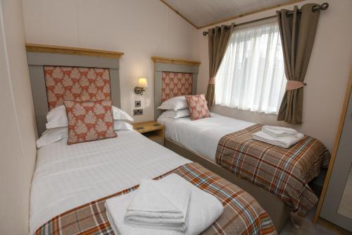 a hotel room with two beds and a window at Lakewood retreat in Woodhall Spa