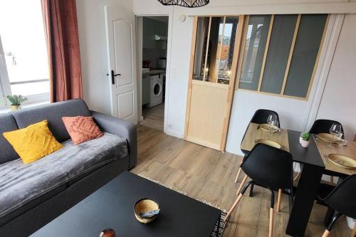 a living room with a couch and a table at appartement cosy in Boulogne-sur-Mer