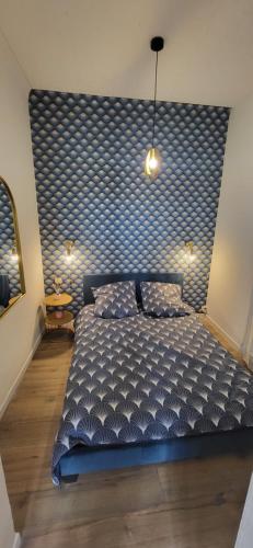 une chambre avec un grand lit avec une tête de lit bleue dans l'établissement appartement cosy, à Boulogne-sur-Mer