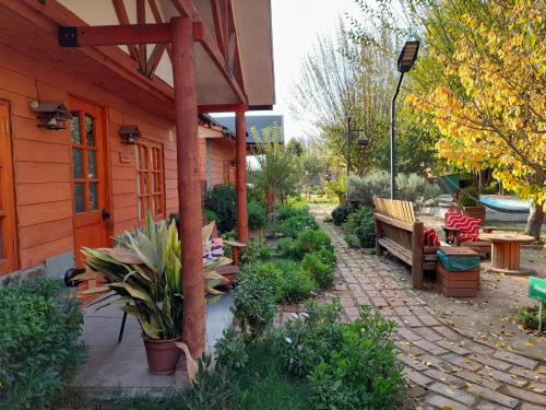 a garden with benches and plants next to a building at Cabañas Refugio Nativo in Santa Cruz