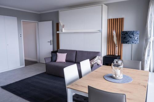 a living room with a table and a couch at Golden Hour Apartment Wangerooge in Wangerooge