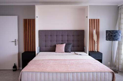 um quarto com uma cama grande e uma almofada rosa em Golden Hour Apartment Wangerooge em Wangerooge