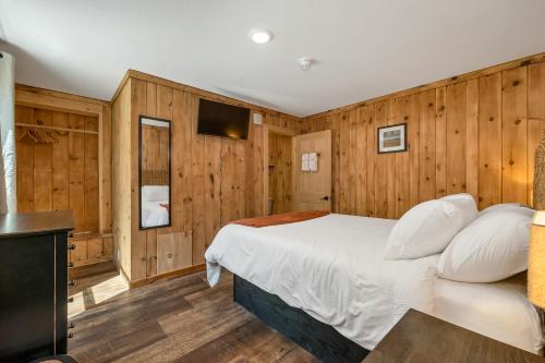 a bedroom with wooden walls and a bed with white pillows at The Inn & More in Bartlett