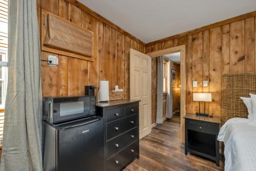a bedroom with wooden walls and a bed and a television at The Inn & More in Bartlett