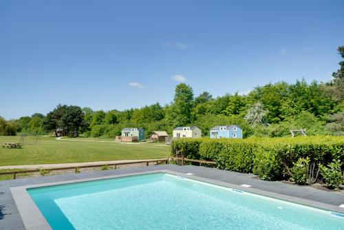 a swimming pool in the backyard of a home at Green Tiny House with shared pool in Zeewolde