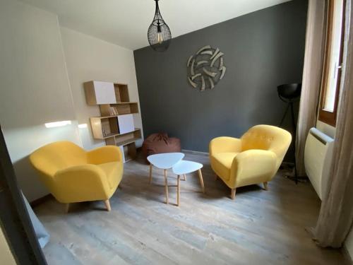 a living room with two yellow chairs and a table at Marie Clothilde in Chouilly