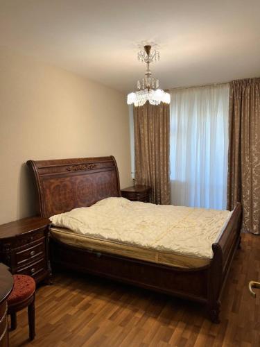 - une chambre avec un grand lit et un lustre dans l'établissement Квартира в центре, à Tachkent