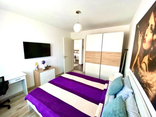 a bedroom with a bed and a desk and a tv at Relaxing Coresi Place in Braşov
