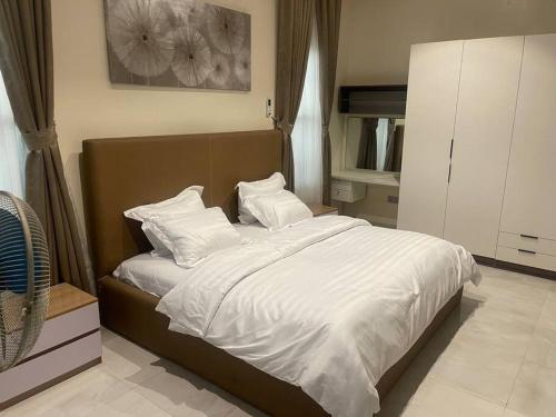1 dormitorio con 1 cama con sábanas y almohadas blancas en Urban Haven - Surulere, en Lagos