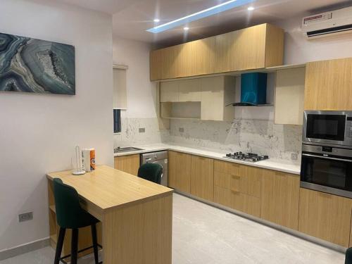 a kitchen with wooden cabinets and a counter top at Urban Haven - Surulere in Lagos