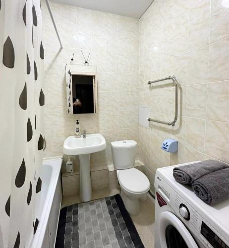 庫斯塔奈的住宿－Комфортабельные - уютные апартаменты в Костанай мкр Береке1，浴室配有盥洗盆、卫生间和浴缸。