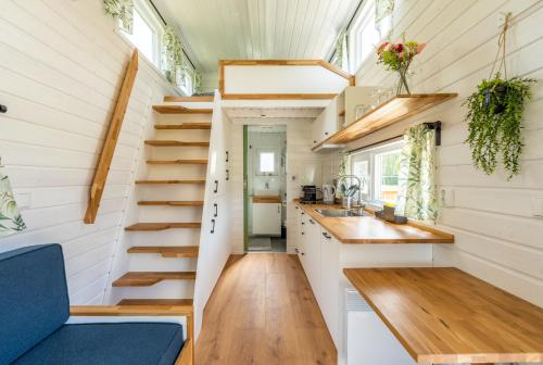 ein kleines Haus mit Treppen und einer Küche in der Unterkunft Green Tiny House with shared pool in Zeewolde