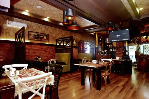 ein Restaurant mit Tischen und Stühlen sowie einem TV in der Unterkunft Antika Hotel in Batumi