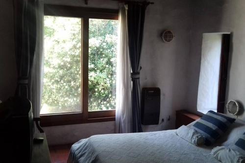 a bedroom with a bed and a large window at club de campo los horneros in Ingeniero Maschwitz