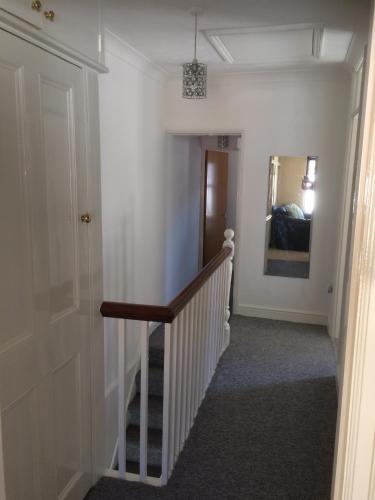 um corredor com uma escada que leva a um quarto em Hockham em Kings Lynn