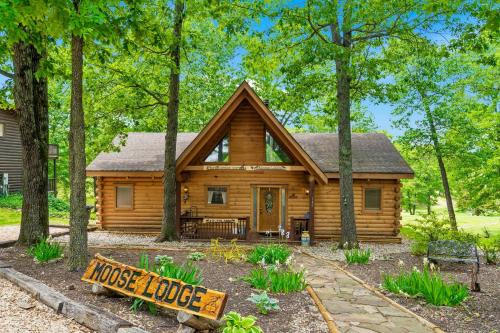 a log cabin in the woods with a sign in front at Moose Lodge w/HotTub in Ridgedale