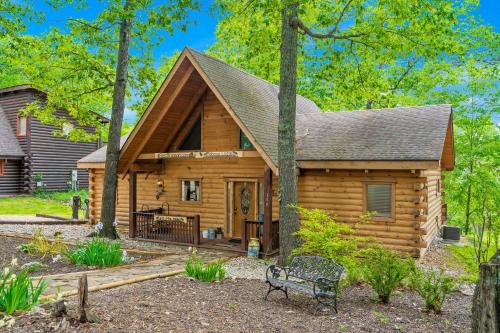 a log cabin with a bench in front of it at Moose Lodge w/HotTub in Ridgedale