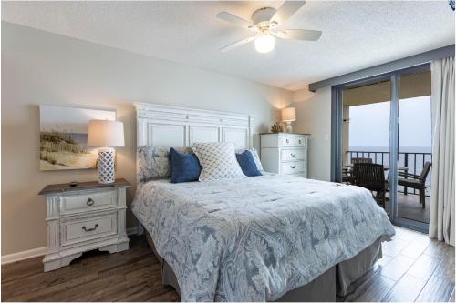 ein Schlafzimmer mit einem Bett mit blauer Decke und einem Fenster in der Unterkunft Phoenix III 3084 in Orange Beach