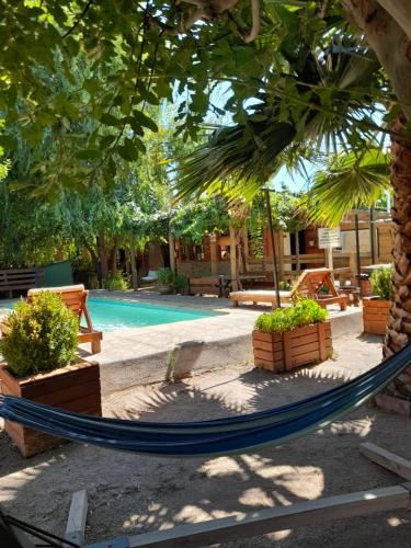 a hammock in front of a swimming pool at Cabañas Refugio Nativo in Santa Cruz