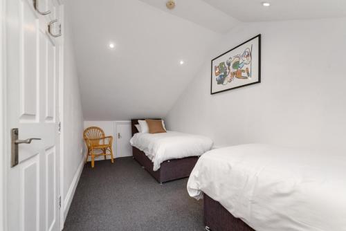 a small bedroom with two beds and a chair at The Penthouse 3 Minutes To The Beach, Super Comfy Beds, Part of Burlington-Escapes in Brighton & Hove