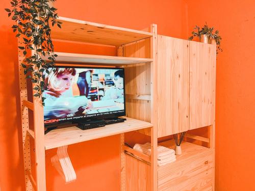 a television in a wooden book shelf in a room at Casa del Arroyo 2-Bedroom Cottage Fireplace and BBQ in Jarabacoa