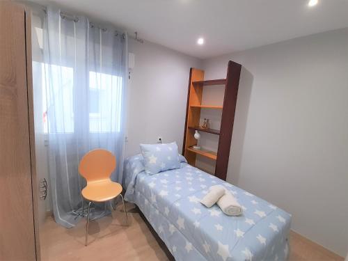ein kleines Schlafzimmer mit einem Bett und einem Stuhl in der Unterkunft Gran apartamento 7 plazas centro de Oviedo-OV4729 in Oviedo