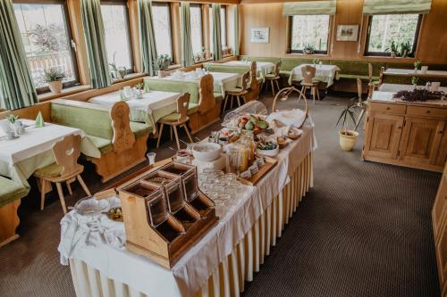 uma sala de jantar com mesas e cadeiras e mesa de cabeceira em Feldgärtenhof em Silandro