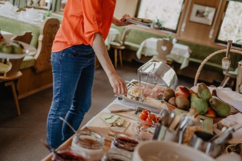 a woman standing in front of a buffet at Feldgärtenhof in Silandro
