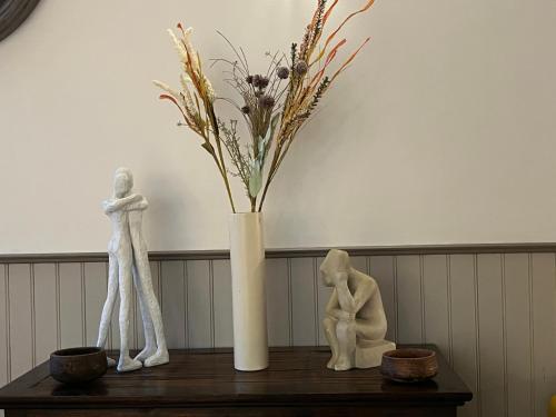 a vase with flowers in it sitting on a table at Le Clos d'Orange - Hotel & ville de Provence in Orange