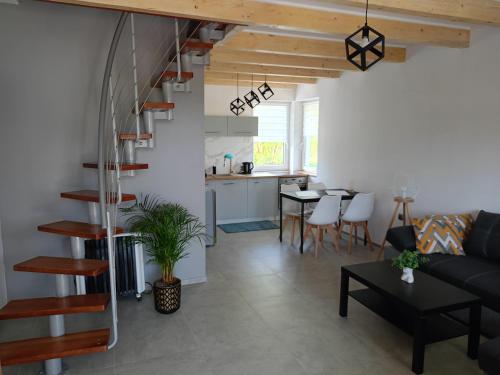 a living room and dining room with a spiral staircase at Domki Brzezówka nad stawami in Kłodzko