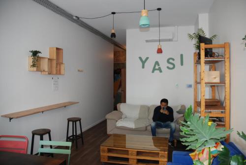 a man sitting on a couch in a living room at YASI Hostel in Lyon