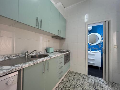una cocina con armarios blancos y fregadero en Oporto Blue Lapa - Original Citycenter House!, en Oporto