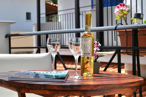 a bottle of wine and two glasses on a table at Pansion Pandora in Skiathos Town