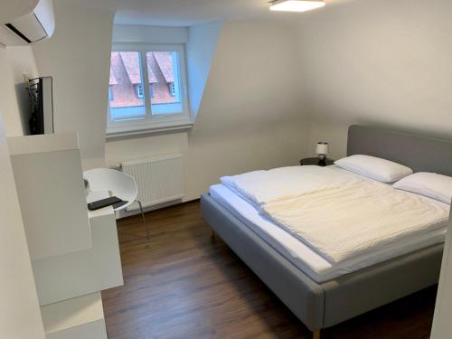 1 dormitorio con cama y ventana en Apartment im alten Rathaus en Malterdingen