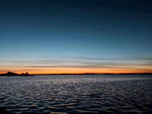 a sunset over a large body of water at Tiny house ''De Veenpolder'' in De Veenhoop