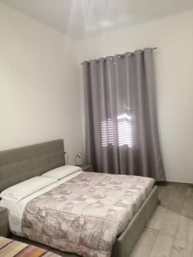 a bedroom with a bed and a window with curtains at AFFITTACAMERE S.ORSOLA - MALPIGHI in Bologna