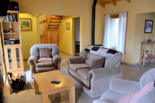 sala de estar con 2 sillas y sofá en A la grande le puse Cuca - AmunaPatagonia en San Martín de los Andes