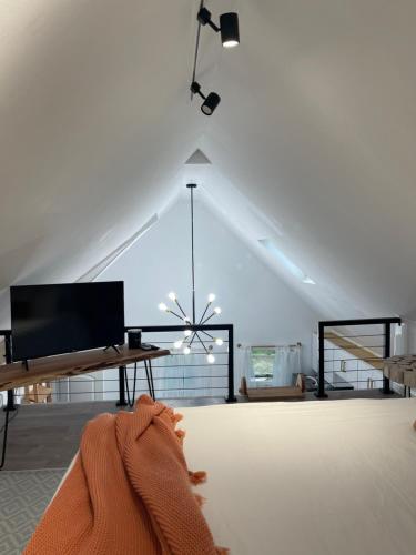 a living room with a tv and a table at Modern Loft in East Rockaway