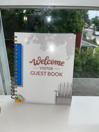 a welcome visitor guest book sitting on a table at Modern Loft in East Rockaway