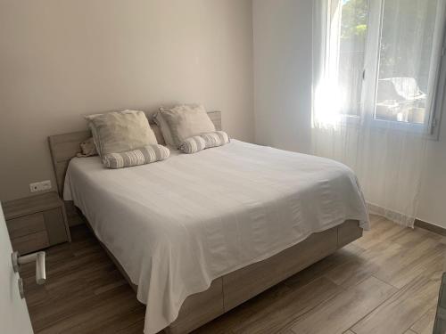 une chambre avec un lit avec des draps blancs et une fenêtre dans l'établissement Magnifique Villa idéalement située, à Puget-sur Argens