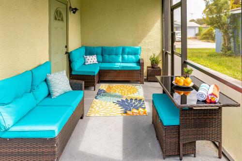 un patio con sofás azules y una mesa en Marlin's Palm Oasis - Beach House, Amazing Pool, BBQ Area, en Port Richey