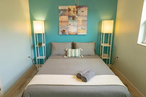 1 dormitorio con 1 cama grande y 2 lámparas en Marlin's Palm Oasis - Beach House, Amazing Pool, BBQ Area, en Port Richey